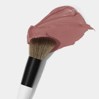 Makeup By Mario's F1 Dual-Ended Contour and blush brush dipped in cream blush.